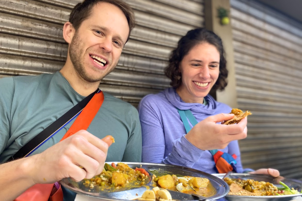 International guests enjoying stuffed parathas during Harry's Delhi Food Tour at Paranthe Wali Gali in Old Delhi.