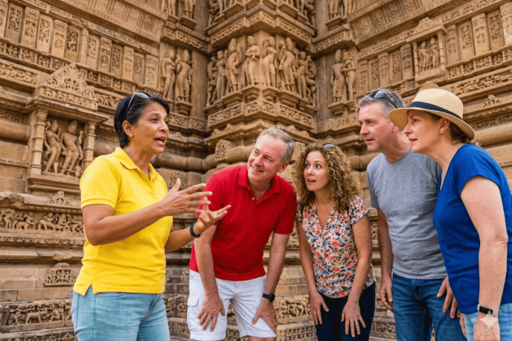 Beautiful ancient stone temples of Khajuraho with intricate carvings under a clear blue sky during a custom India heritage tour