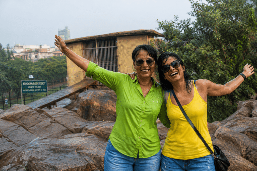 Delhi tour guide enjoying monsoon rain at the hilltop pavilion of Ashokan Rock Edicts, one of the hidden places in Delhi